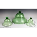 Three green glass plant cloche, each of bell form and with bun shaped handle/knop,