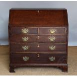 A George III oak bureau, with two short and three long drawers, on bracket feet,