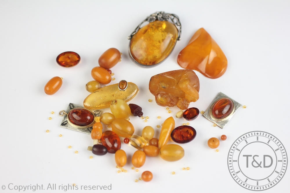 A selection of amber and amber coloured beads, carvings, panels and plaques,
