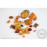 A selection of amber and amber coloured beads, carvings, panels and plaques,