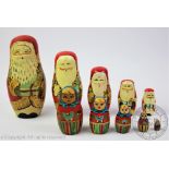 A Russian stacking Matryoshka Father Christmas doll, enclosing four smaller examples, tallest 18cm,