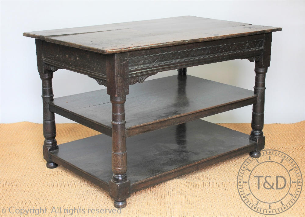 An 18th century and later oak three tier table, with side drawer, on turned legs,