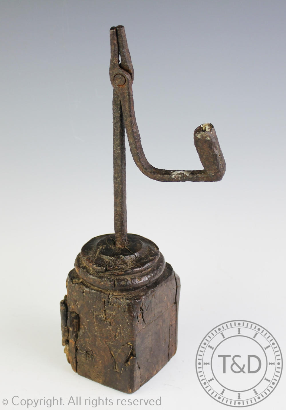 A primitive 18th century iron rush nip light, upon a later oak block base,
