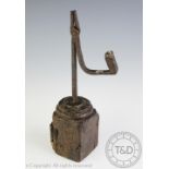 A primitive 18th century iron rush nip light, upon a later oak block base,