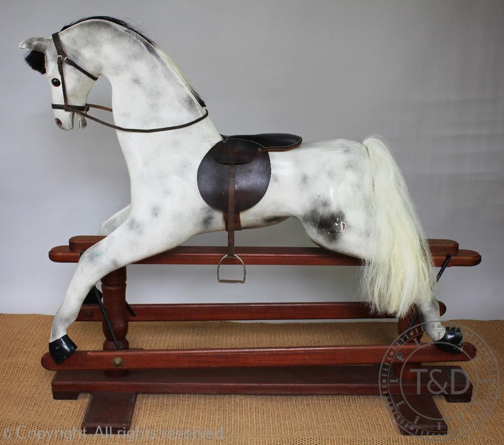 A modern painted wood dappled grey rocking horse, on walnut base,