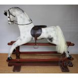 A modern painted wood dappled grey rocking horse, on walnut base,