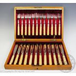 An Edwardian cased set of twelve fish knives and forks, each with etched blades and ivorine handles,