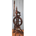 An early 20th century oak and mahogany spinning wheel on turned supports,