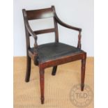 A late George III mahogany carver dining chair, with reeded arms on ring turned and tapered legs,