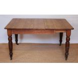 A late Victorian pitch pine extending dining table, with one spare leaf, on turned legs,