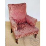 A late Victorian mahogany library club type chair, with floral upholstery, on turned legs,