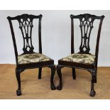 A set of four Chippendale style carved and stained wood dining chairs,