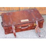 A vintage tan leather suitcase, with brass clasps,