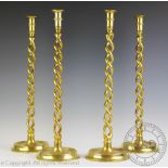 A set of four brass altar style candlesticks, each with double barley twist stems,