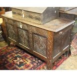 An early 18th century oak coffer, panelled front with later carved detailing, on stile legs,