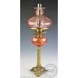 A Victorian oil lamp with cranberry glass shade,