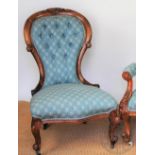 A Victorian carved walnut button back salon chair, with patterned blue upholstery, on scroll legs,