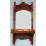 An Edwardian carved mahogany wall mirror, with column sides and fret cut detailing,