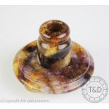 An early 20th century Derbyshire Blue John candlestick, the circular base upon tripod feet,