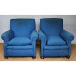 A pair of early 20th century club type library chairs, with blue upholstery, on bun feet,