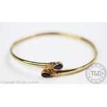 A yellow gold and sapphire set bangle,