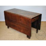 A George III oak gate leg table, with drawer, on tapered legs,