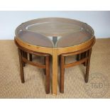A Nathan Furniture circular teak coffee table and three matching eye shaped tables,
