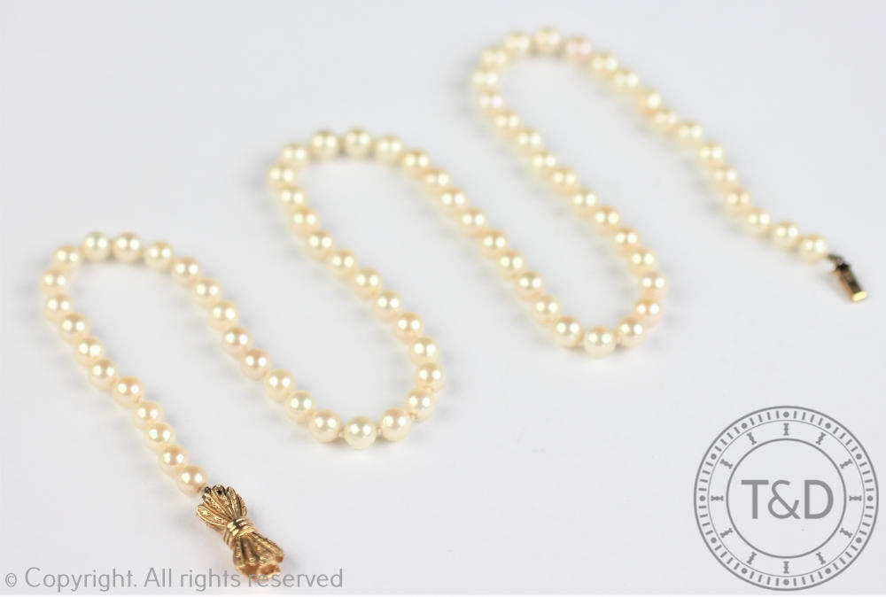 A single strand uniform cultured pearl necklace, with attached 9ct yellow gold bow shaped clasp,