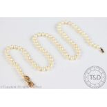 A single strand uniform cultured pearl necklace, with attached 9ct yellow gold bow shaped clasp,