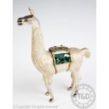 A white metal model of a Llama, modelled standing with green stone set paniers,