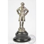 An MGM Pictures figural car mascot modelled as Beau Brummell, upon a circular plinth base,