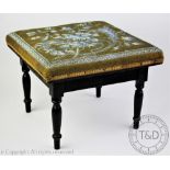 A Victorian ebonised foot stool, the bead work top decorated with flowers, on turned legs,