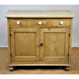 A Victorian style pine cupboard, with three drawers and two cupboard doors, on turned legs,