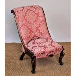 A Victorian carved walnut salon chair, with floral red upholstery, on scroll legs,