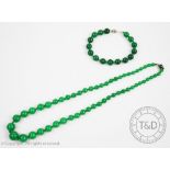 A jade coloured graduated bead necklace with attached bead clasp and a similar coloured bead