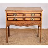 A George III style light oak low boy, with four drawers, on square legs,