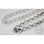 A colourless bead necklace, the beads with silver coloured wire mounts,