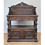 A Victorian carved oak buffet, with raised back above two drawers with lion mask handles,