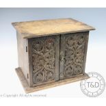 A 17th century style carved oak table cabinet, with two doors enclosing a compartmented interior,