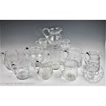 A selection twelve cut glass water jugs, each with star cut bases and handles,