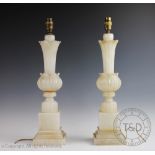 A pair of 20th century alabaster lamp bases, each designed a lotus stem on block plinth base,