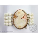 A pale coral coloured bracelet with carved shell cameo clasp,