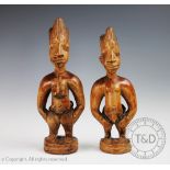 A pair of West African Nigerian carved wood Ibeji dolls, with beads, tallest 29.