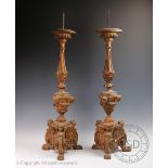 A pair of 19th century and later carved softwood pricket altar sticks,