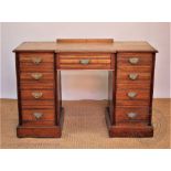 An Edwardian walnut pedestal desk, with nine drawers, on plinth base,