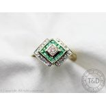 A diamond and emerald ring, designed as a central diamond,