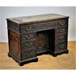 A George III and later carved mahogany architects desk, with two way ratcheted top,