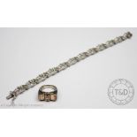 An 18ct white gold bracelet, designed as twelve openwork scroll design panels,