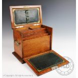 An Edwardian brass mounted oak stationery box, with leather lined and compartmented interior,