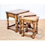 A modern oak nest of three tables, on turned legs,